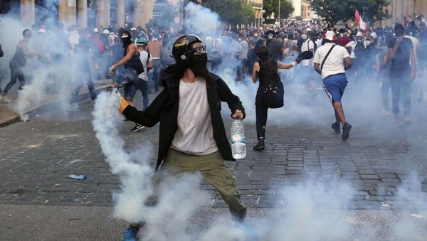 Protesters throw back tear gas canisters towards riot policemen during an anti-government protest, in the aftermath of last Tuesday's massive explosion which devastated Beirut, Lebanon, Monday, Aug. 10, 2020 Protesters throw back tear gas canisters towards riot policemen during an anti-government protest, in the aftermath of last Tuesday's massive explosion which devastated Beirut, Lebanon, Monday, Aug. 10, 2020 - Sputnik International