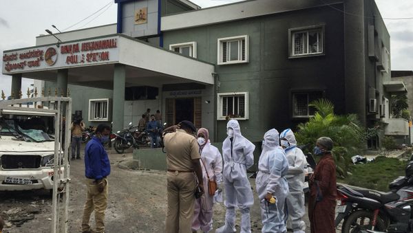 Relatives of a man killed after violence erupted between police and protesters over an alleged derogatory Facebook post about Islam's Prophet Mohammad, speak to a police officer outside a burnt police station, in Bengaluru, India, August 12, 2020 - Sputnik International