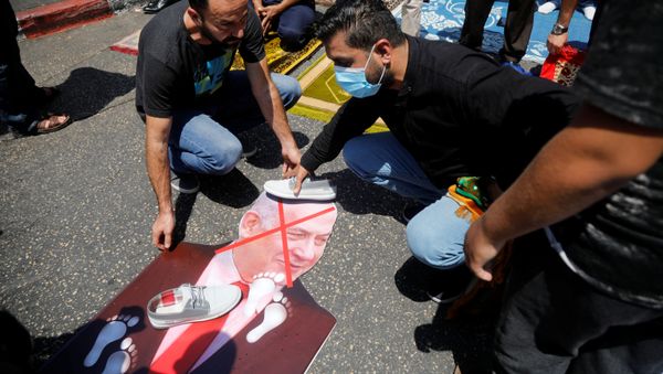 Shoes are placed on a cutout depicting Israeli Prime Minister Benjamin Netanyahu during a protest against the United Arab Emirates' deal with Israel to normalise relations, in Nablus in the Israeli-occupied West Bank August 14, 2020. REUTERS/Raneen Sawafta - Sputnik International