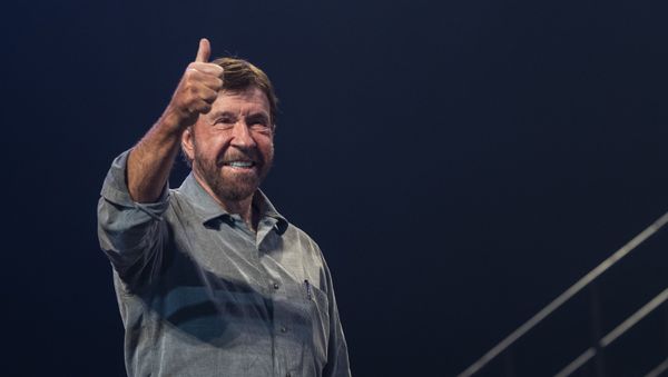 US actor and martial artist Chuck Norris, this year's special guest signals to the audience onstage during the opening gala of the 15th Shoe Box fundraising event in Papp Laszlo Sports Arena in Budapest, Hungary, Saturday, Nov. 24, 2018. The annual Christmas charity campaign was launched by the Hungarian Baptist Aid (HBAid) in 2004 to collect and distribute gifts donated by the public for underprivileged children during Advent. The organisation receives the labelled and boxed presents at nearly 300 designated collection points in the country.  - Sputnik International