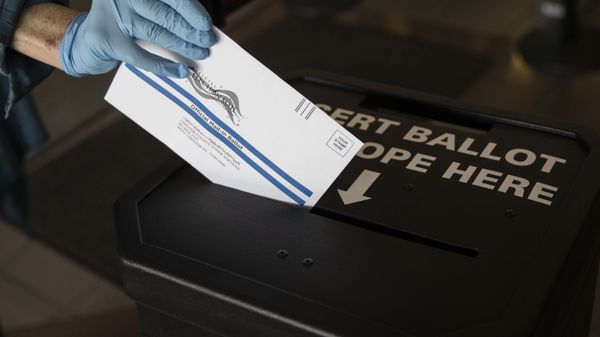 In this 28 May 2020 file photo, a voter casts her mail-in ballot at a drop box in West Chester, Pennsylvania prior to the primary election. Just over four months before Election Day, President Donald Trump is escalating his efforts to delegitimise the upcoming presidential election. - Sputnik International