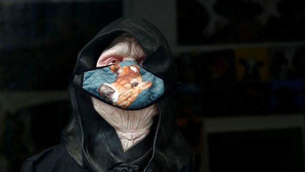 A protective mask is seen displayed on the window of a shop, amid the outbreak of the coronavirus disease (COVID-19), in Windermere, Britain 12 August 2020. - Sputnik International