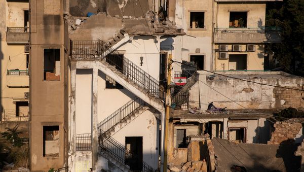 A Lebanese flag hangs in front of the buildings that were damaged by an explosion at the Beirut port, in the neighbourhood of Karantina, Lebanon, August 13, 2020 - Sputnik International