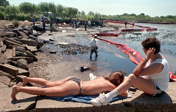 Sunbathers watch workers clean up oil spilled on the resort beach of Playa Nueva in Magdalena, Argentina, 100 km (62 miles) south of Buenos Aires, 21 January 1999. Sunbathers watch workers clean up oil spilled on the resort beach of Playa Nueva in Magdalena, Argentina, 100 km (62 miles) south of Buenos Aires, 21 January 1999. - Sputnik International