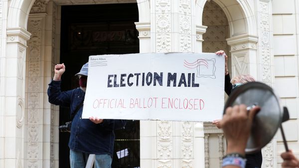 Demonstrators hold a large mock mail-in ballot as others hit pans and pots during a protest against changes in the postal service outside of the condo of Postmaster General Louis DeJoy, as the spread of the coronavirus disease (COVID-19) continues, in Washington, U.S., August 15, 2020.  - Sputnik International