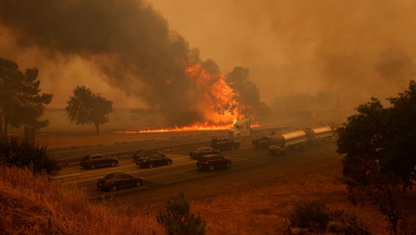 Vehicles are seen along Interstate 80 as flames from the LNU Lighting Complex Fire are seen on both sides on the outskirts of Vacaville, California, U.S. August 19, 2020 - Sputnik International