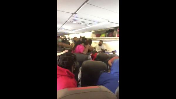 Cellphone recording captures moment in which an all-out brawl broke out on American Airlines flight 1665 after a passenger refused to wear a face mask, in line with the airline's policies. - Sputnik International