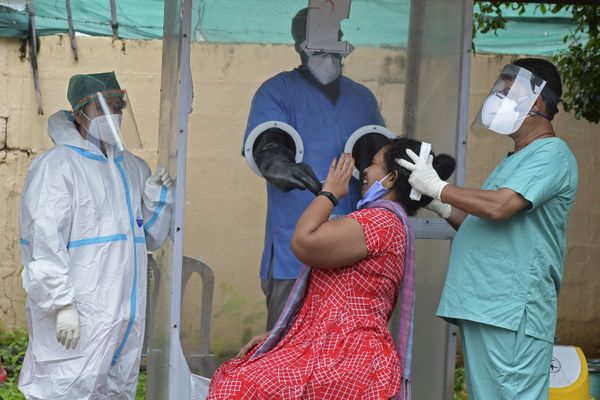 A health worker wearing personal protective equipment (PPE) collects a swab sample from a woman at a free COVID-19 coronavirus testing centre in Hyderabad on 19 August 2020.  - Sputnik International