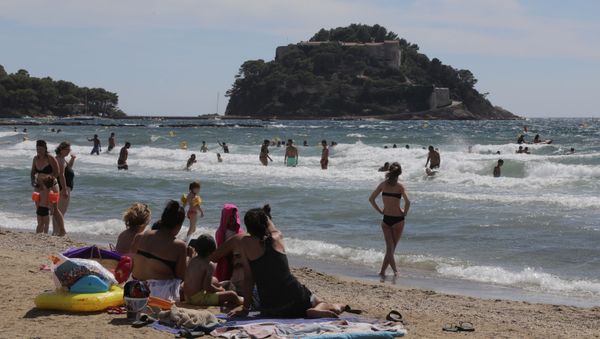 People sunbathe on the beach of Bregancon fort, the French presidential summer residence, where French President Emmanuel Macron stays for holidays in Bormes-les-Mimosas, August 17, 2020 - Sputnik International