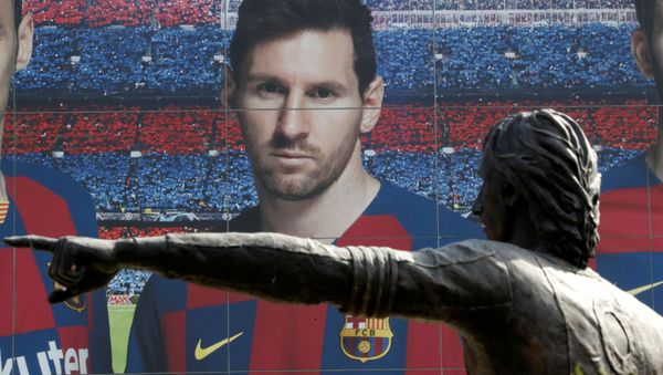 Soccer Football - Camp Nou, Barcelona, Spain - August 26, 2020   A statue of Johan Cruyff is seen infront of an image of Lionel Messi outside the Camp Nou after captain Lionel Messi told Barcelona he wishes to leave the club immediately, a source confirmed on Tuesday    - Sputnik International