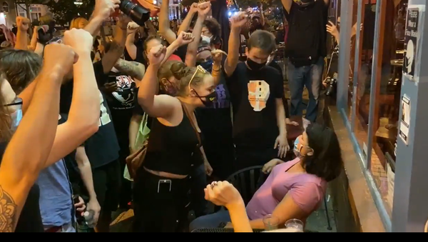 A screenshot from a video showing BLM protestors confronting diners outside a DC restaurant - Sputnik International