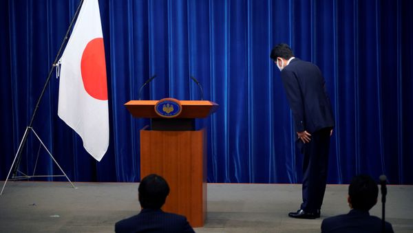 Japanese Prime Minister Shinzo Abe bows to the national flag at the start of a news conference at the prime minister's official residence in Tokyo, Japan, August 28, 2020 - Sputnik International