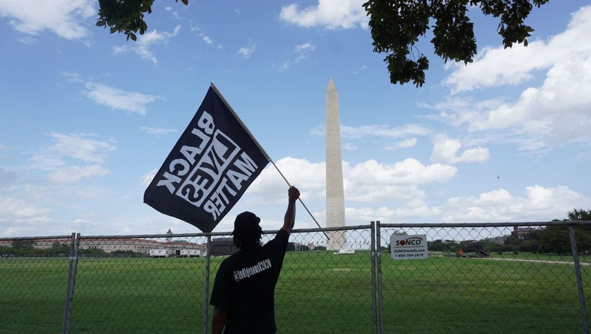 A participant of the rally commemorating the 57th anniversary of the March on Washington is seen holding a Black Lives Matter flag in front of the Washington Monument. A participant of the rally commemorating the 57th anniversary of the March on Washington is seen holding a Black Lives Matter flag in front of the Washington Monument. - Sputnik International, 1920, 31.05.2021