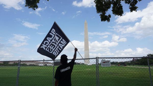 A participant of the rally commemorating the 57th anniversary of the March on Washington is seen holding a Black Lives Matter flag in front of the Washington Monument. - Sputnik International