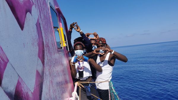 In this undated handout photo people pose for a photo after being rescued by the Louise Michel, a migrants search and rescue ship operating in the Mediterranean and financed by British street artist Banksy, at sea. In this undated handout photo people pose for a photo after being rescued by the Louise Michel, a migrants search and rescue ship operating in the Mediterranean and financed by British street artist Banksy, at sea. - Sputnik International