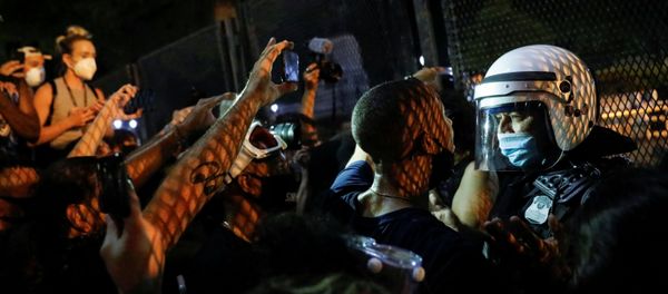 Demonstrators face off with a security officer near a fence around the White House during a protest in Washington, U.S. August 27, 2020 Demonstrators face off with a security officer near a fence around the White House during a protest in Washington, U.S. August 27, 2020 - Sputnik International