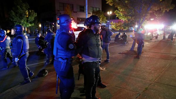 Police officers detain a demonstrator during a protest against police violence and racial injustice in Portland, Oregon, U.S., August 24, 2020.   - Sputnik International
