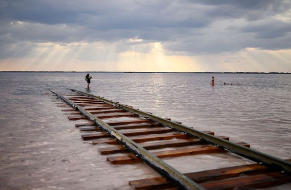 People rest in the Burlinskoye lake in Russia's Altay region. A railway line is needed to remove salt which is being extracted from the lake. People rest in the Burlinskoye lake in Russia's Altay region. A railway line is needed to remove salt which is being extracted from the lake. - Sputnik International
