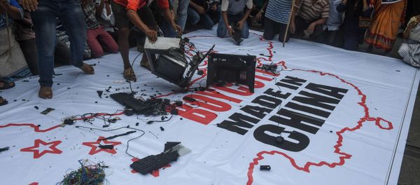 Congress party supporters leave Chinese goods on a flag displaying the country and flag of China along with an inscription reading 'Boycott Made in China' before burning them during an anti-China demonstration in Kolkata on Juane 18, 2020 - Sputnik International