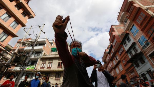 A man uses a slingshot during the protest after locals try to pull the chariot of Rato Machhindranath amid the ban on public and religious gatherings to control the spread of the coronavirus disease (COVID-19) in Lalitpur, Nepal September 3, 2020 - Sputnik International