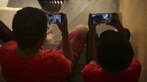 Indian children play online game PUBG on their mobile phones sitting on stairs outside their house  in Hyderabad, India, Friday, April 5, 2019.  - Sputnik International