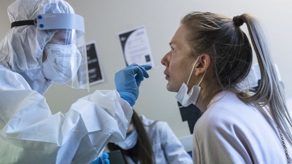 A medical worker, left, performs a COVID-19 test at a test center at Vnukovo airport outside Moscow, Russia, Friday, Aug. 7, 2020. Authorities in Russia say they are about to approve a COVID-19 vaccine, with mass vaccinations planned as early as October 2020, using shots that are yet to complete clinical trials - Sputnik International