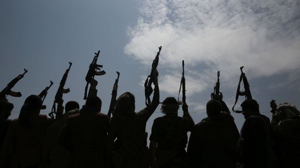 A silhouette of tribesmen loyal to Houthi rebels raise their weapons as they chant slogans during a gathering against the agreement to establish diplomatic relations between Israel and the United Arab Emirates in Sanaa, Yemen, Saturday, Aug. 22, 2020.  - Sputnik International