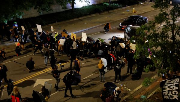 Demonstrators take cover as cars pass during a protest over the death of a Black man, Daniel Prude, after police put a spit hood over his head during an arrest on March 23, in Rochester, New York, U.S. September 4, 2020 - Sputnik International