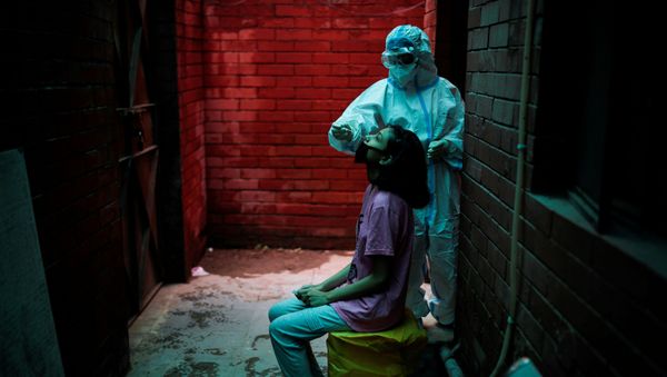 A health worker in personal protective equipment (PPE) collects a sample using a swab from a person at a local health centre to conduct tests for the coronavirus disease (COVID-19), amid the spread of the disease, in New Delhi, India August 31, 2020. A health worker in personal protective equipment (PPE) collects a sample using a swab from a person at a local health centre to conduct tests for the coronavirus disease (COVID-19), amid the spread of the disease, in New Delhi, India August 31, 2020. - Sputnik International