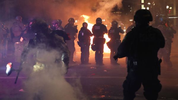 Federal Law Enforcement officers fire teargas and less lethal munitions at protesters during a demonstration against racial inequality and police violence in downtown Portland, Oregon, U.S. July 25, 2020. Picture taken July 25, 2020.  - Sputnik International