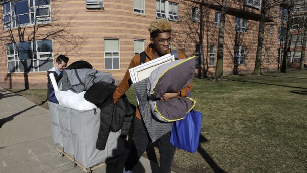Northeastern University sophomore Philip Thomas, of Hamden, Conn., front, pulls a cart of belongings as he moves out of his residence hall as classmate Jarrett Anderson, of Las Vegas, left, assists him, Sunday, March 15, 2020, in Boston. Students have been asked by the school to move out of residence halls out of concern about the spread of the coronavirus. For most people, the new coronavirus causes only mild or moderate symptoms, such as fever and cough. For some, especially older adults and people with existing health problems, it can cause more severe illness, including pneumonia. The vast majority of people recover from the new virus. - Sputnik International