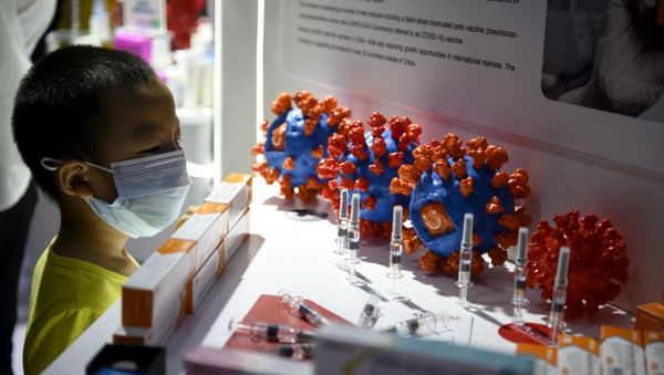 A boy looks at Sinovac Biotech LTD's vaccine candidate for COVID-19 coronavirus on display at the China International Fair for Trade in Services (CIFTIS) in Beijing on September 6, 2020. - Sputnik International