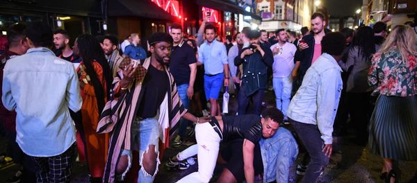 Revellers dance in the street in the Soho area of London on July 4, 2020, following a further easing of restrictions to allow pubs and restaurants to open during the novel coronavirus COVID-19 pandemic.  - Sputnik International