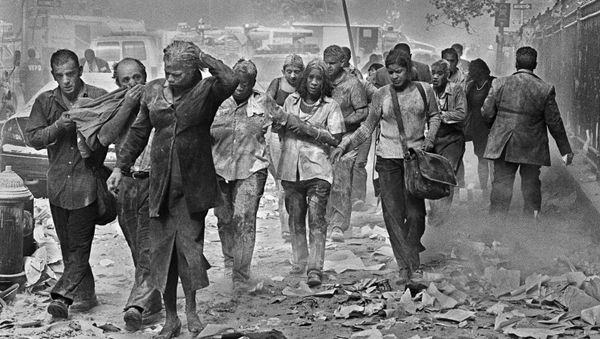 Survivors of the terrorist attacks on the World Trade Center in New York make their way through smoke, dust and debris on Fulton St., about a block from the collapsed towers in this Tuesday, September 11, 2001 file photo. - Sputnik International