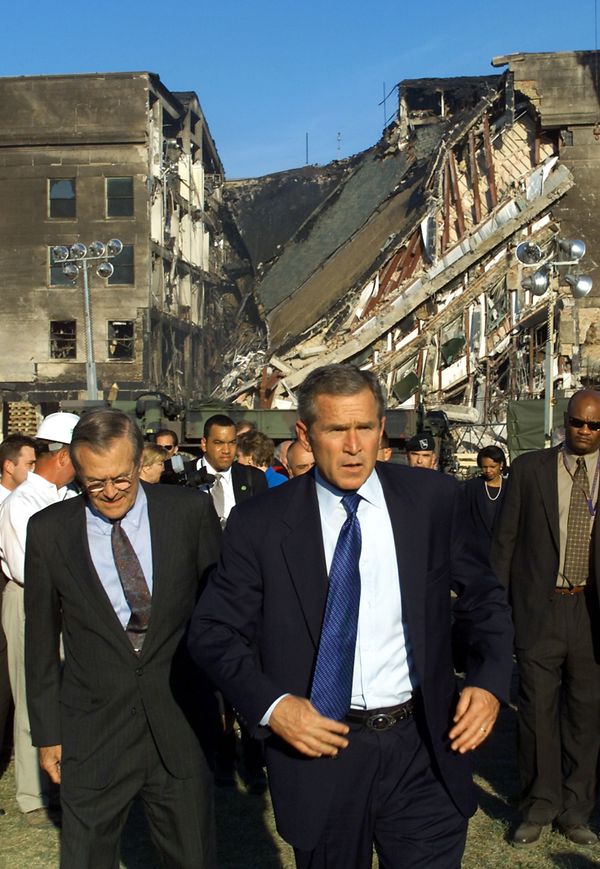 Then-US President George W. Bush (C) and then-US Secretary of Defence Donald Rumsfeld (L) tour the impact area (rear) at the Pentagon on 12 September 2001, where a hijacked airline was crashed into the building as part of a coordinated terrorist attack on the US Then-US President George W. Bush (C) and then-US Secretary of Defence Donald Rumsfeld (L) tour the impact area (rear) at the Pentagon on 12 September 2001, where a hijacked airline was crashed into the building as part of a coordinated terrorist attack on the US - Sputnik International