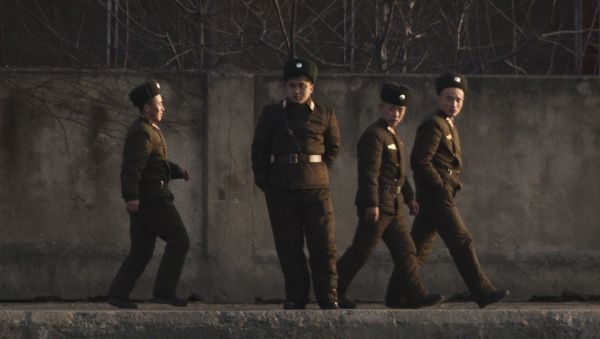 North Korean soldiers walk along the river bank of the North Korean town of Sinuiju, opposite side to the Chinese border city of Dandong, Tuesday, Dec. 20, 2011 - Sputnik International