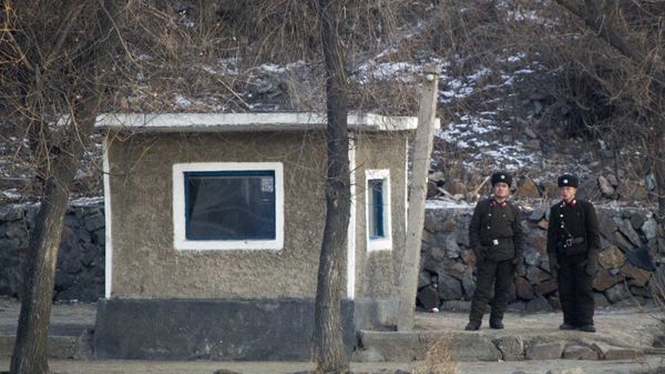 North Korean soldiers look as they stand guard along the river bank of the North Korean town of Sinuiju, opposite side to the Chinese border city of Dandong, Tuesday, Dec. 20, 2011 - Sputnik International