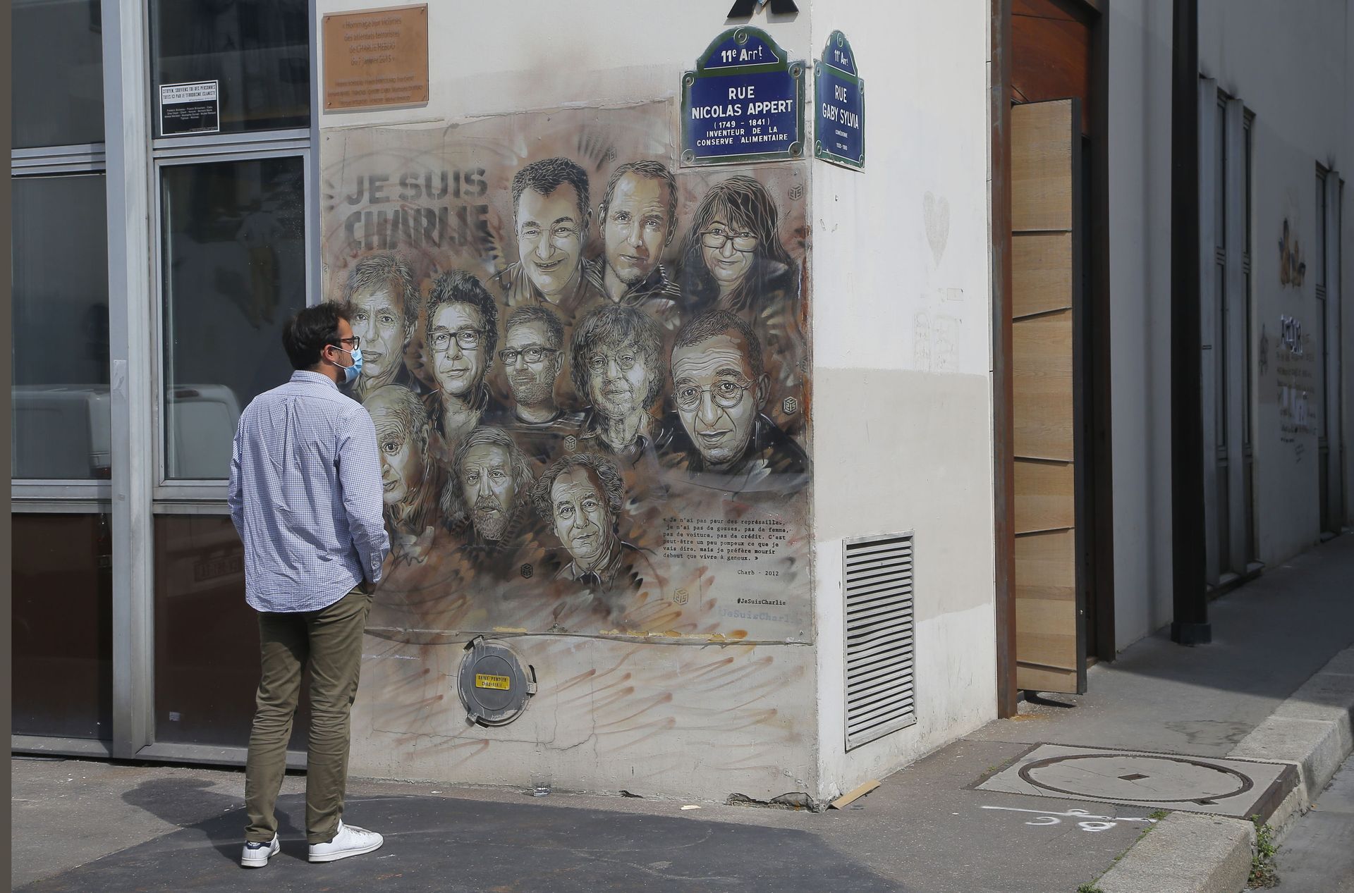 A man wearing a protective face mask as a precaution against the coronavirus looks on a painting by French street artist Christian Guemy, a.k.a. 'C215' in Paris Wednesday, Sept. 2, 2020, in tribute to the members of the satirical newspaper Charlie Hebdo attack by jihadist gunmen in January 2015. Thirteen men and a woman go on trial Wednesday over the 2015 attacks against a satirical newspaper and a kosher supermarket in Paris that marked the beginning of a wave of violence by the Islamic State group in Europe. Seventeen people and all three gunmen died during the three days of attacks in January 2015 A man wearing a protective face mask as a precaution against the coronavirus looks on a painting by French street artist Christian Guemy, a.k.a. 'C215' in Paris Wednesday, Sept. 2, 2020, in tribute to the members of the satirical newspaper Charlie Hebdo attack by jihadist gunmen in January 2015. Thirteen men and a woman go on trial Wednesday over the 2015 attacks against a satirical newspaper and a kosher supermarket in Paris that marked the beginning of a wave of violence by the Islamic State group in Europe. Seventeen people and all three gunmen died during the three days of attacks in January 2015 - Sputnik International, 1920, 07.09.2021
