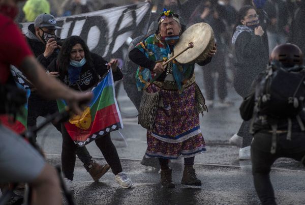 A Mapuche indigenous woman plays the drum as riot police use water cannons to disperse demonstrators during a protest against the government's handling of the COVID-19 novel coronavirus pandemic, in Santiago, on September 4, 2020 A Mapuche indigenous woman plays the drum as riot police use water cannons to disperse demonstrators during a protest against the government's handling of the COVID-19 novel coronavirus pandemic, in Santiago, on September 4, 2020 - Sputnik International