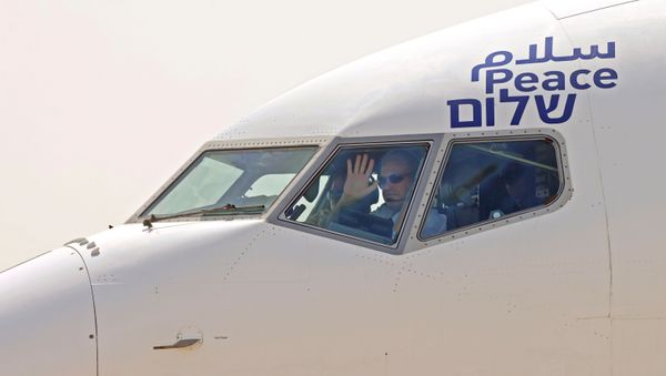 The captain of the El Al's airliner, which will carry a U.S.-Israeli delegation to the UAE following a normalisation accord, waves to spectators as they prepare for lift-off in the first-ever commercial flight from Israel to the UAE at Ben Gurion Airport, near Tel Aviv, Israel August 31, 2020.  - Sputnik International