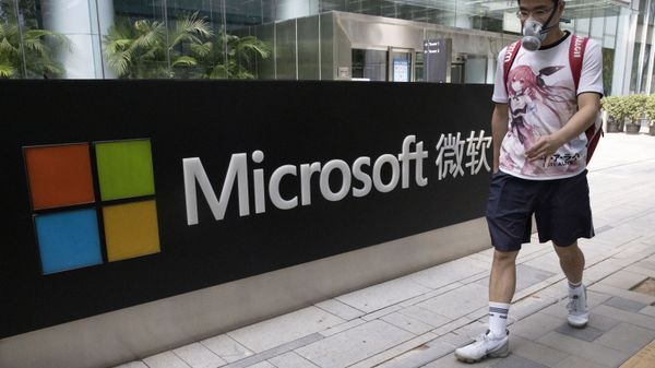 A man wearing a mask walks past the Microsoft office in Beijing, China on Friday. - Sputnik International