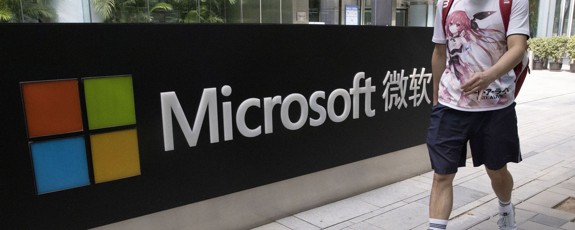 A man wearing a mask walks past the Microsoft office in Beijing, China on Friday. - Sputnik International, 1920, 18.01.2023