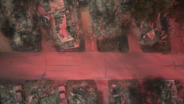 A search and rescue team, surrounded by red fire retardant, look for victims under burned residences and vehicles in the aftermath of the Almeda fire in Talent, Oregon, U.S., September 13, 2020 - Sputnik International
