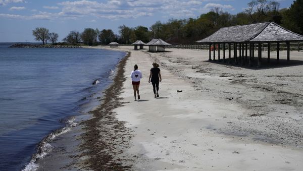 Women walk along the beach on the Long Island Sound on Tod's Point in Old Greenwich, Connecticut on May 7, 2020. Women walk along the beach on the Long Island Sound on Tod's Point in Old Greenwich, Connecticut on May 7, 2020. - Sputnik International