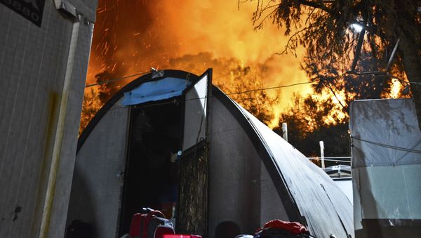 A fire burns behind the refugee and migrant camp in Samos Island Greece, late Monday, Oct. 14, 2019 - Sputnik International