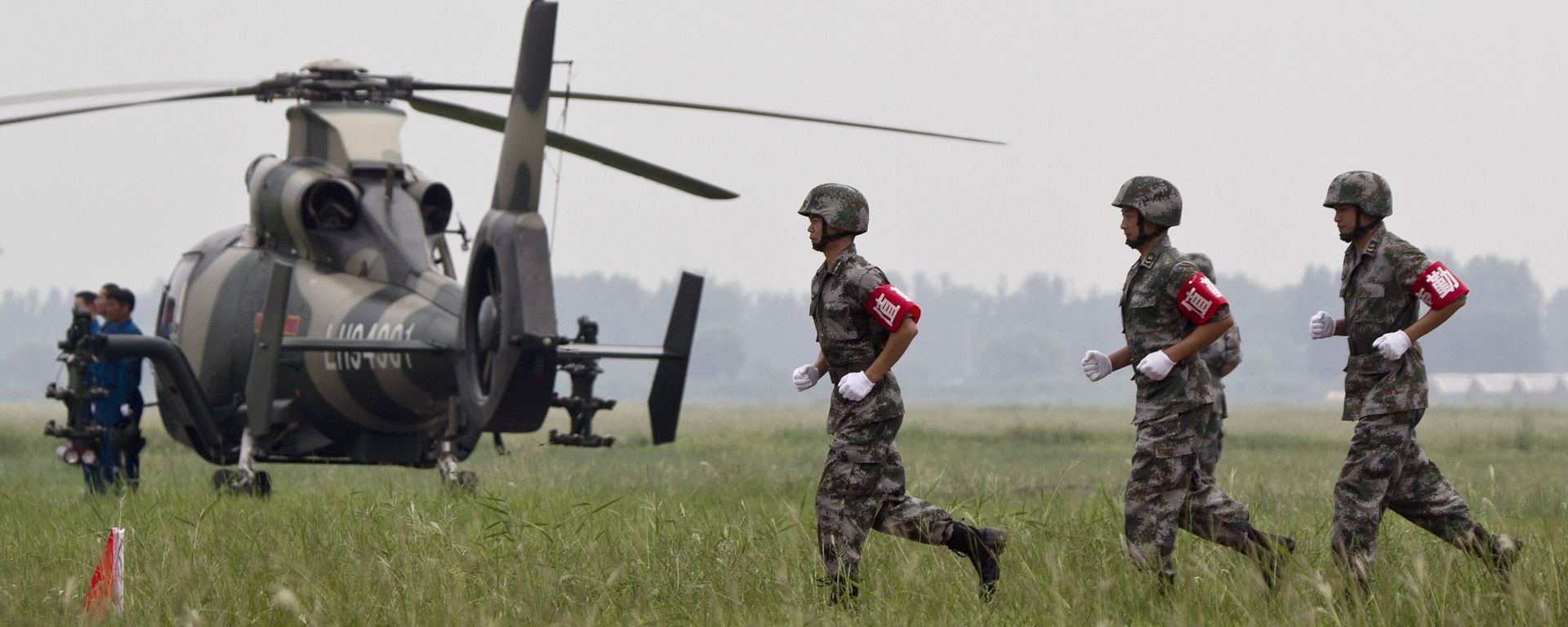  Chinese soldiers run near a Z-9WZ attack helicopter, designed and manufactured by China (File) - Sputnik International, 1920, 02.05.2022