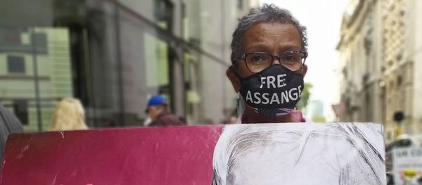 Assange supporter with a banner outside the Old Bailey on 15 September 2020 - Sputnik International