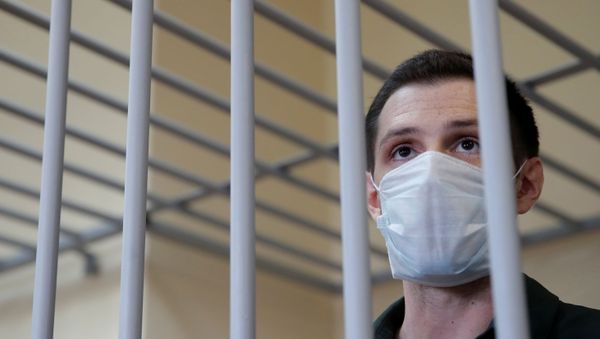 Former U.S. Marine Trevor Reed, who was detained in 2019 and accused of assaulting police officers, stands inside a defendants' cage during a court hearing in Moscow, Russia July 30, 2020. - Sputnik International