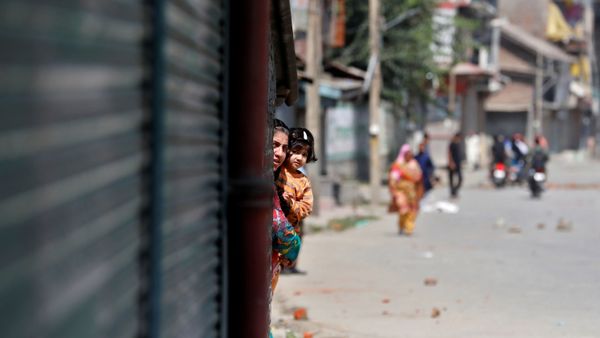 A Kashmiri woman holds a girl as they watch a protest after a gun battle between suspected militants and Indian security forces in Srinagar  - Sputnik International