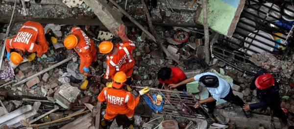 National Disaster Response Force (NDRF) officials and firemen remove debris as they look for survivors after a three-storey residential building collapsed in Bhiwandi on the outskirts of Mumbai, India, September 21, 2020. National Disaster Response Force (NDRF) officials and firemen remove debris as they look for survivors after a three-storey residential building collapsed in Bhiwandi on the outskirts of Mumbai, India, September 21, 2020. - Sputnik International